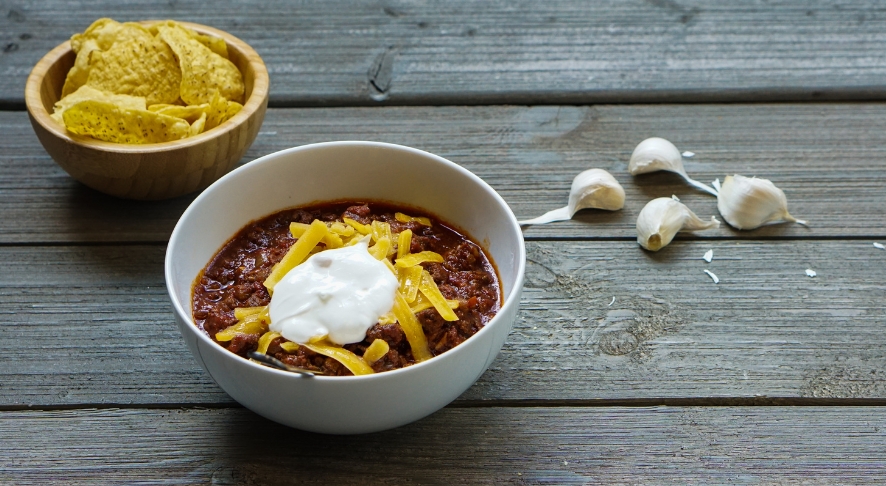 A bowl of all-beef chili with a side of tortilla chips.